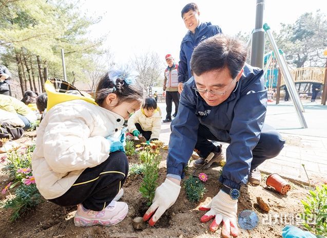 진교훈 서울 강서구청장(오른쪽)이 23일 방화근린공원에서 열린 ‘제81회 식목일 나무 심기 행사’에서 아이들과 꽃을 심고 있다.