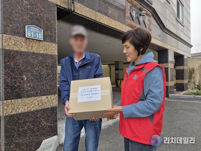 명예사회복지공무원이 대상자 가정을 방문해 꾸러미를 전달하는 모습