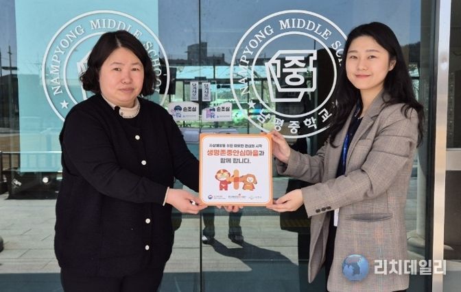 나주시보건소가 남평중학교에 생명 존중 안심마을 현판을 전달하고 있다.